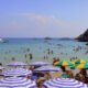 ola calor España — Bañistas disfrutan de las aguas del mar en una playa con sombrillas durante la ola de calor en España. Foto de: Pixabay