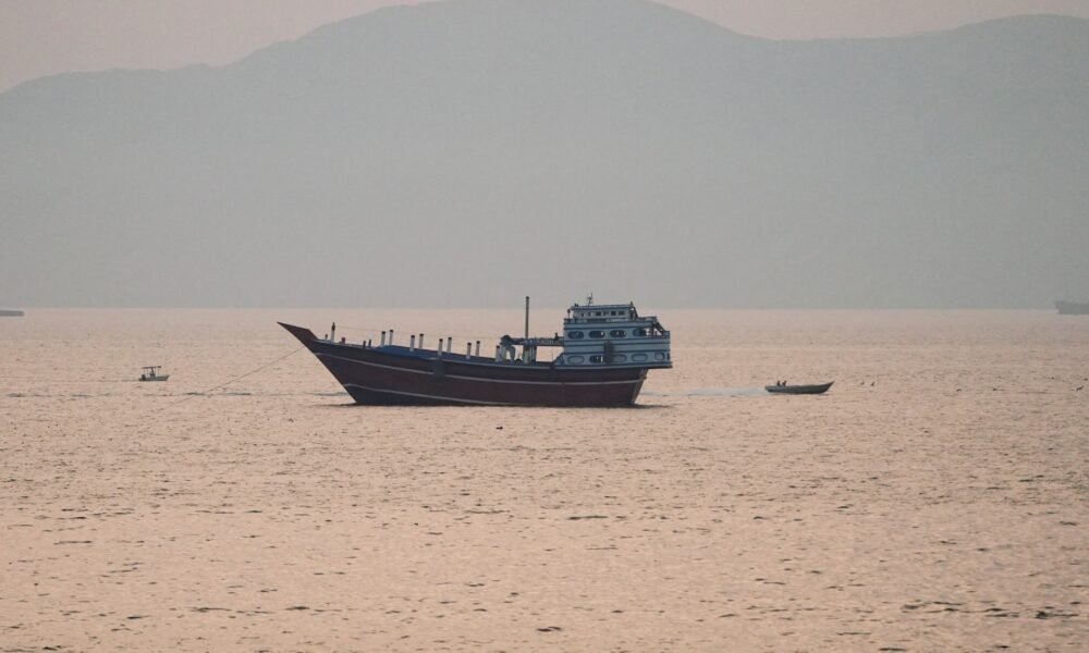 Estados Unidos — Un barco de carga navega por aguas tranquilas en una zona que evoca el estrecho de Hormuz. Foto de: Al Jazeera