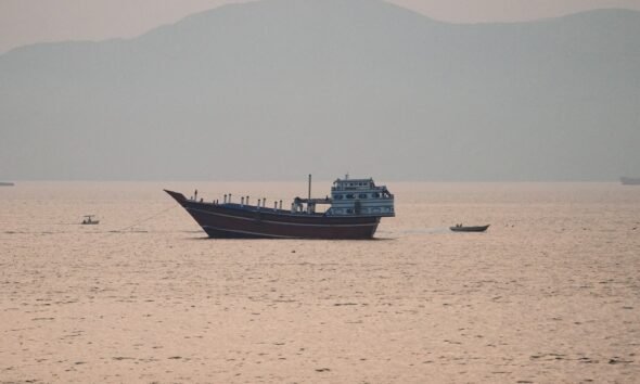 Estados Unidos — Un barco de carga navega por aguas tranquilas en una zona que evoca el estrecho de Hormuz. Foto de: Al Jazeera