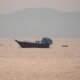 Estados Unidos — Un barco de carga navega por aguas tranquilas en una zona que evoca el estrecho de Hormuz. Foto de: Al Jazeera
