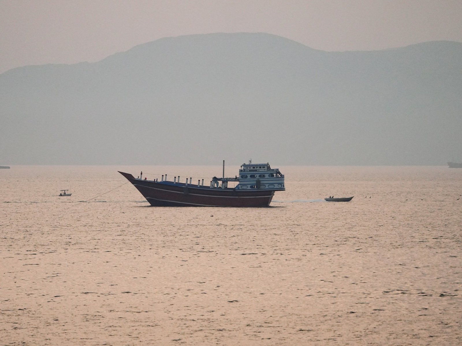 Estados Unidos — Un barco de carga navega por aguas tranquilas en una zona que evoca el estrecho de Hormuz. Foto de: Al Jazeera