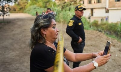crisis de seguridad — Una vecina graba con su teléfono móvil una escena en la que se observa a un oficial de policía. Foto de: Rodrigo Abd / Ap Photo/rodrigo Abd