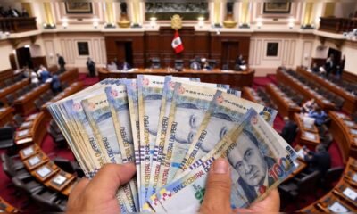 gasto planilla Congreso — Billetes de 100 soles peruanos sobre el fondo del Congreso de la República frente al aumento en el gasto de planillas. Foto de: La República