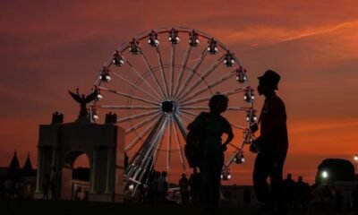 entidad ligada — Una noria gigante se recorta contra un cielo anaranjado durante el atardecer en una feria de la celebración del 250 aniversario de Estados Unidos. Foto de: CNN en Español