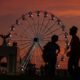 entidad ligada — Una noria gigante se recorta contra un cielo anaranjado durante el atardecer en una feria de la celebración del 250 aniversario de Estados Unidos. Foto de: CNN en Español