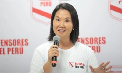 credencial Keiko Fujimori — Una mujer con camiseta blanca y logo de 'Defensor del Perú' sostiene un micrófono frente a un fondo institucional. Foto de: La República