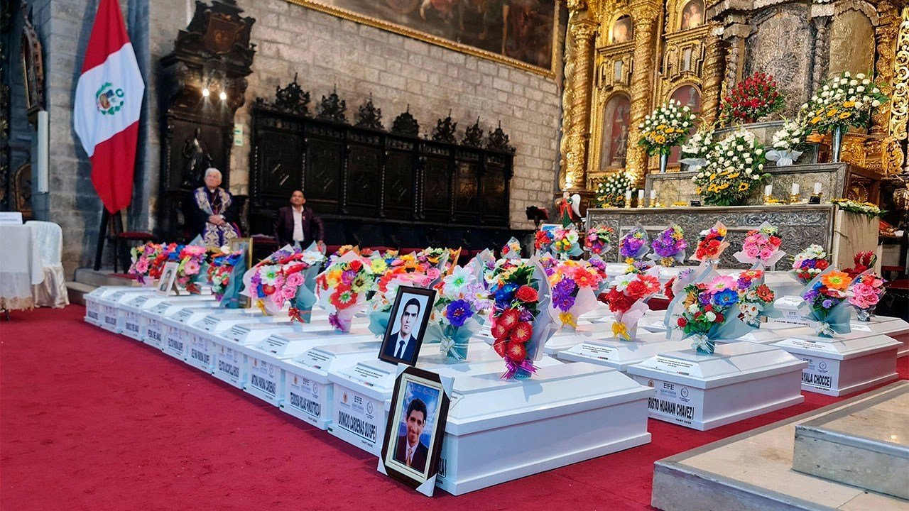 Ministerio Público — Una iglesia decorada con flores coloridas y retratos de personas sobre bloques blancos frente a un altar dorado. Foto de: El Búho