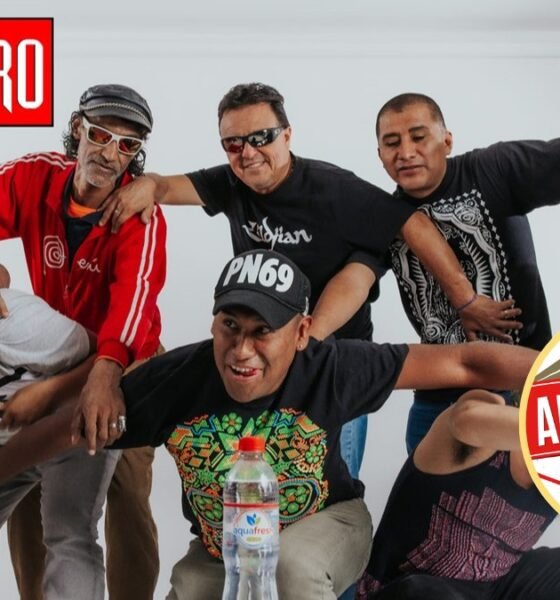 Nicky Jam — Un grupo de hombres posan sonrientes frente a un fondo blanco con logotipos y un anuncio publicitario. Foto de: El Búho
