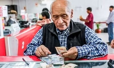 pensión adicional fiestas patrias — Un hombre mayor revisa sus documentos y dinero en una ventanilla de atención, representando a los pensionistas que recibirán un pago adicional. Foto de: El Peruano