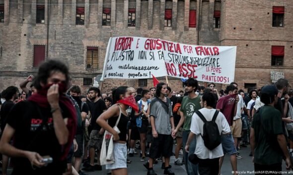 policías heridos — Manifestantes en Italia portan pancartas durante las protestas contra la construcción de una nueva línea ferroviaria. Foto de: Nicola Marfia