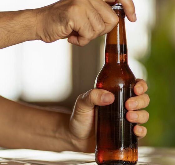 Una persona abre una botella de cerveza, ilustrando la venta de bebidas alcohólicas sin restricciones de horario. Foto de: Gestión