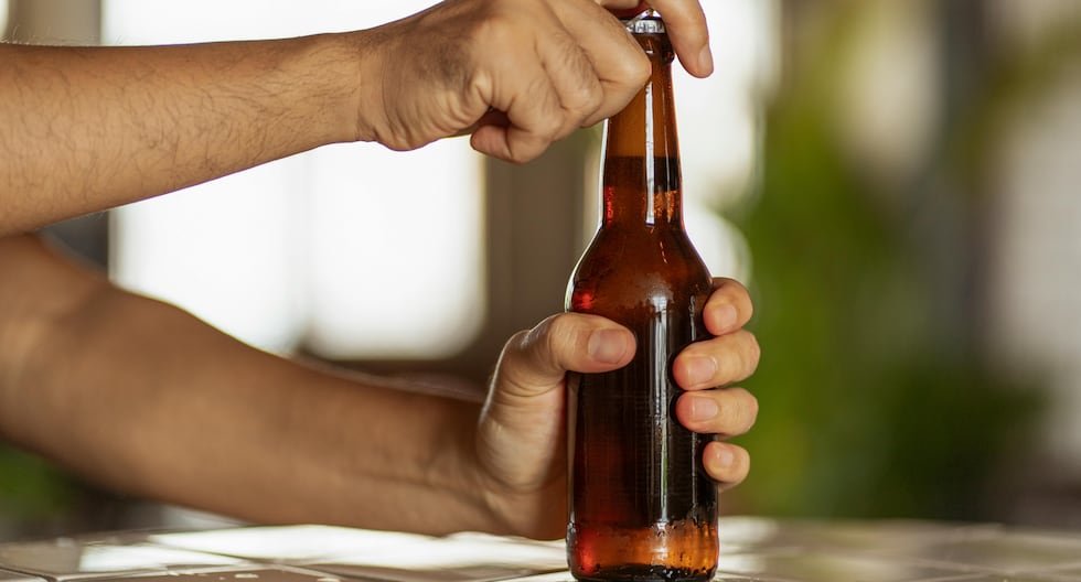 Una persona abre una botella de cerveza, ilustrando la venta de bebidas alcohólicas sin restricciones de horario. Foto de: Gestión