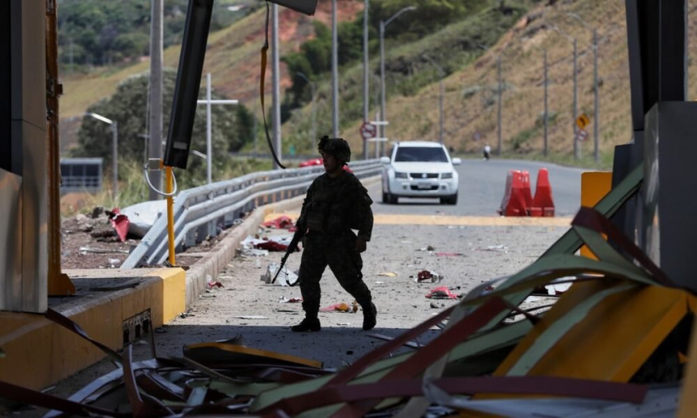 carro bomba — Un soldado patrulla una plaza de peaje en la carretera Panamericana dañada por una explosión tras el atentado con bomba en Colombia. Foto de: Santiago Saldarriaga/AP Photo
