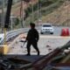 carro bomba — Un soldado patrulla una plaza de peaje en la carretera Panamericana dañada por una explosión tras el atentado con bomba en Colombia. Foto de: Santiago Saldarriaga/AP Photo