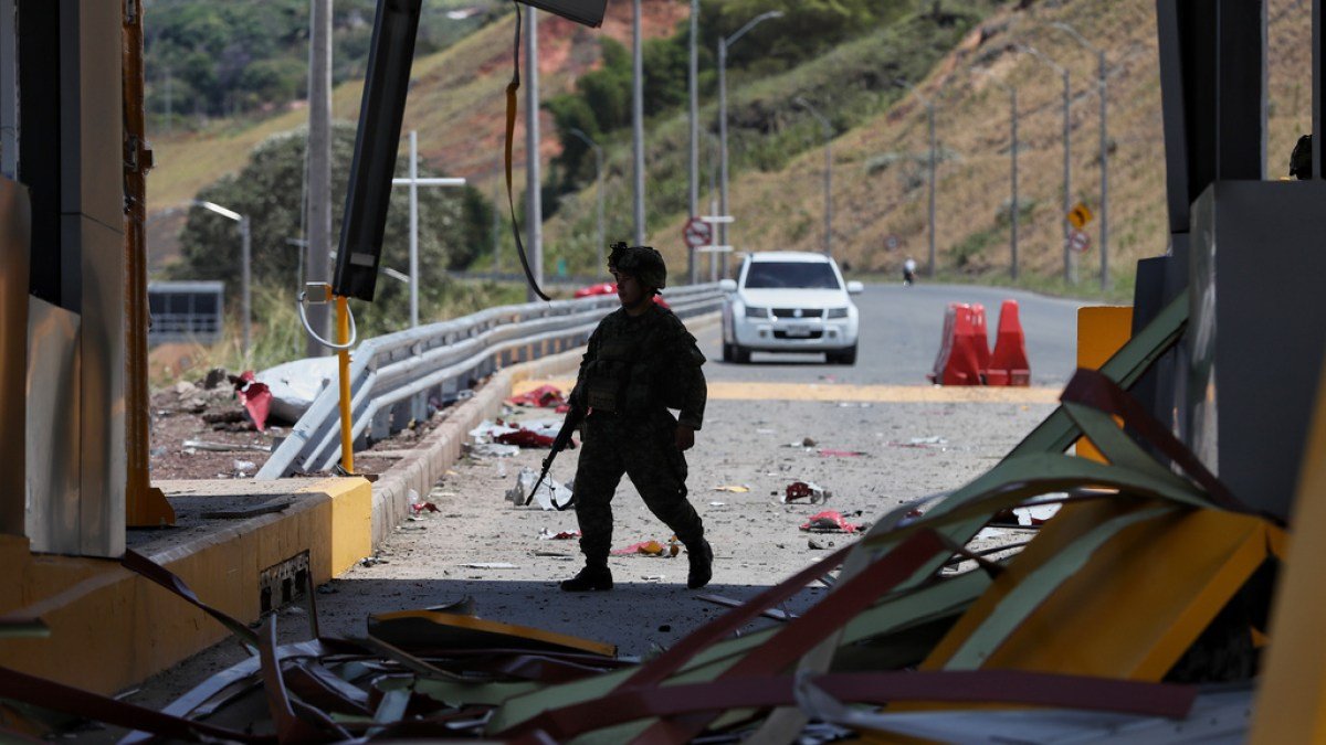 carro bomba — Un soldado patrulla una plaza de peaje en la carretera Panamericana dañada por una explosión tras el atentado con bomba en Colombia. Foto de: Santiago Saldarriaga/AP Photo