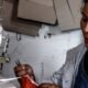 Lima Metropolitana — Una mujer de rasgos asiáticos opera una máquina de coser industrial mientras sostiene una pieza de tela roja. Foto de: Gestión