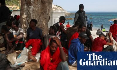crisis migratoria Ceuta — Personas descansan bajo la sombra de un árbol en una playa de Ceuta tras el cruce masivo de la frontera. Foto de: The Guardian
