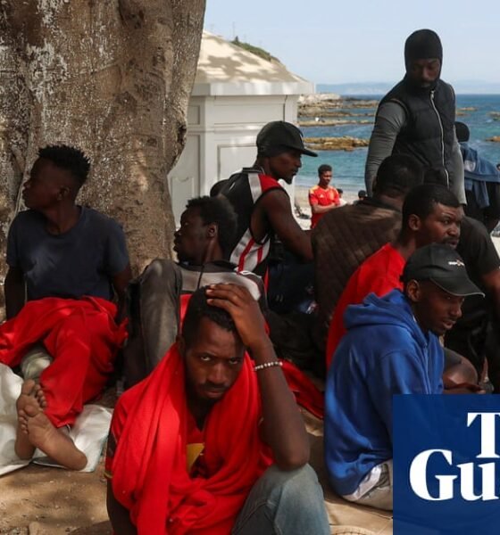 crisis migratoria Ceuta — Personas descansan bajo la sombra de un árbol en una playa de Ceuta tras el cruce masivo de la frontera. Foto de: The Guardian