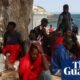 crisis migratoria Ceuta — Personas descansan bajo la sombra de un árbol en una playa de Ceuta tras el cruce masivo de la frontera. Foto de: The Guardian