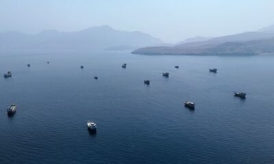 ataques EE.UU. Irán — Varios botes pequeños anclados en aguas tranquilas frente a una costa montañosa bajo un cielo brumoso. Foto de: CNN en Español