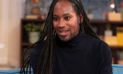 abuso sostenido Jason Arday — Retrato de un hombre con rastas largas y una sonrisa, vistiendo un suéter de cuello alto oscuro. Foto de: CNN en Español