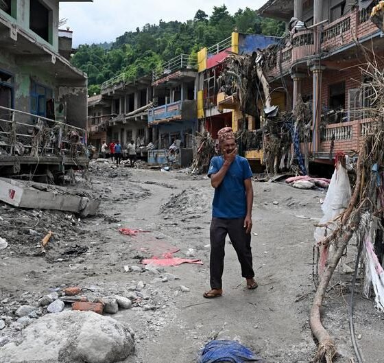 inundaciones Nepal — Un hombre camina entre viviendas dañadas por las inundaciones repentinas en el distrito de Nuwakot, Nepal. Foto de: Arun Sharma/AFP