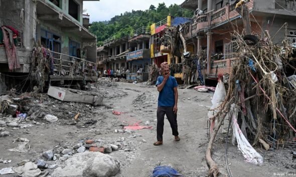 inundaciones Nepal — Un hombre camina entre viviendas dañadas por las inundaciones repentinas en el distrito de Nuwakot, Nepal. Foto de: Arun Sharma/AFP