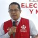 reelección inmediata — Un hombre con gafas y un chaleco rojo que dice JNE Presidente habla frente a un micrófono en un evento. Foto de: Gestión