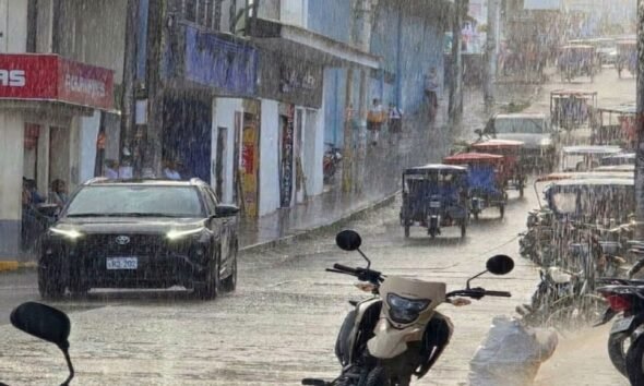friaje Perú agosto — Vehículos y personas transitan por una calle bajo la lluvia en una zona comercial durante el periodo de friaje en Perú. Foto de: Gestión