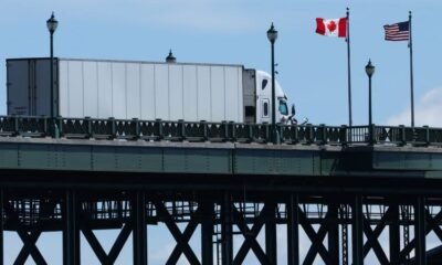 productos canadienses — Un camión de carga circula por un puente con banderas de Canadá y Estados Unidos, simbolizando el comercio entre ambas naciones. Foto de: CNN en Español