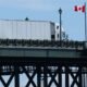 productos canadienses — Un camión de carga circula por un puente con banderas de Canadá y Estados Unidos, simbolizando el comercio entre ambas naciones. Foto de: CNN en Español