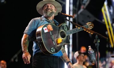 Zac Brown sonríe mientras toca su guitarra durante una presentación en vivo. Foto de: Chris Unger/Zuffa LLC