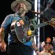 Zac Brown sonríe mientras toca su guitarra durante una presentación en vivo. Foto de: Chris Unger/Zuffa LLC