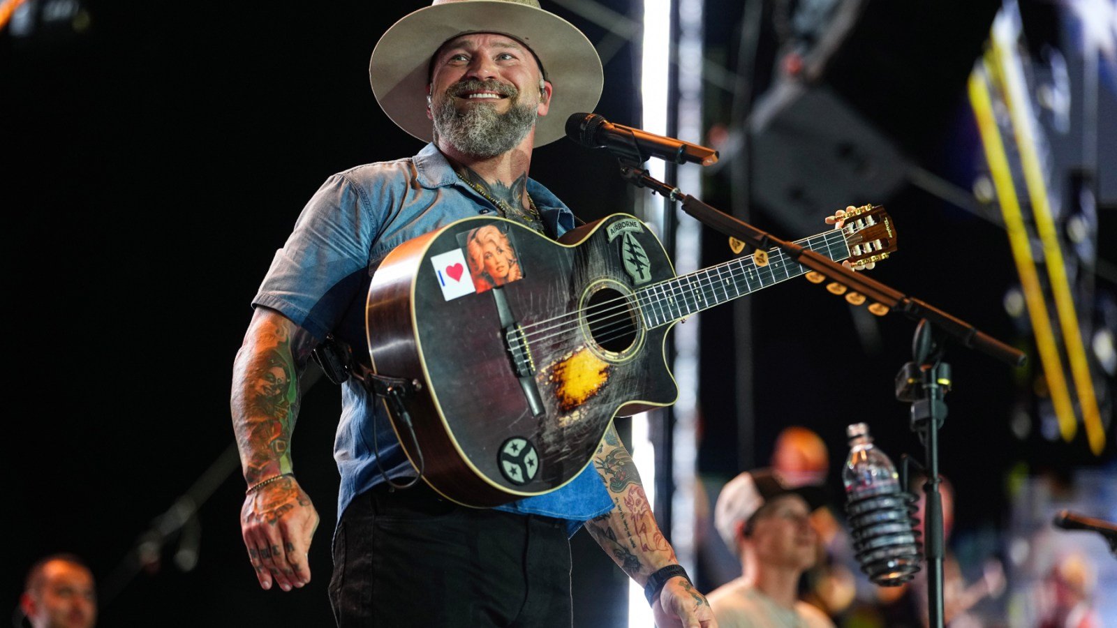 Zac Brown sonríe mientras toca su guitarra durante una presentación en vivo. Foto de: Chris Unger/Zuffa LLC
