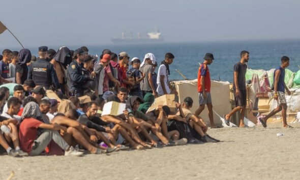 crisis migratoria Ceuta — Agentes de seguridad y migrantes se congregan en la playa de El Trampolín en el marco de la crisis migratoria en Ceuta. Foto de: Javier Hernández