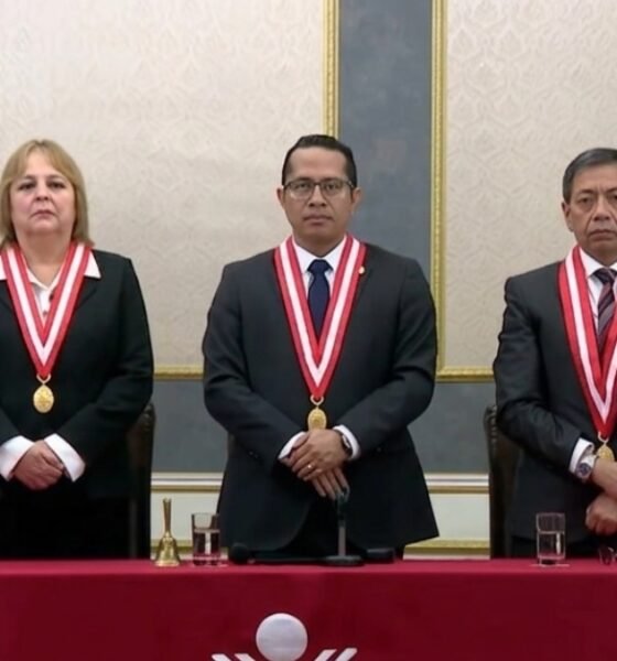 valla electoral — Cinco personas con trajes oscuros y medallas ceremoniales posan en una mesa larga frente a una bandera de México. Foto de: Exitosa Noticias