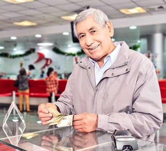ONP establece cronograma — Un hombre sonriente sostiene un documento en un establecimiento, representando a los beneficiarios que recibirán sus pensiones de la ONP. Foto de: El Peruano