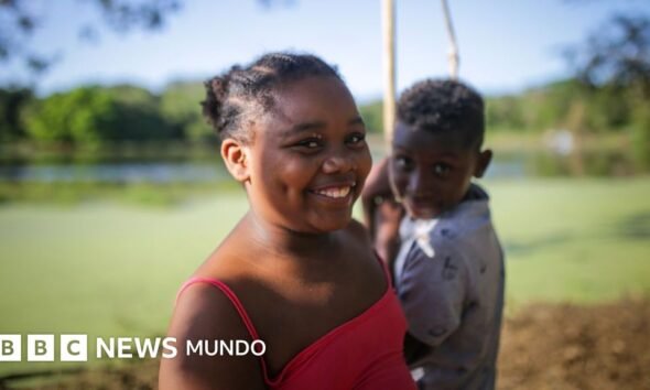 Dos niños sonríen frente a un cuerpo de agua en la isla colombiana de San Andrés, en el Caribe. Foto de: Juancho Torres/Anadolu Agency via Getty Images