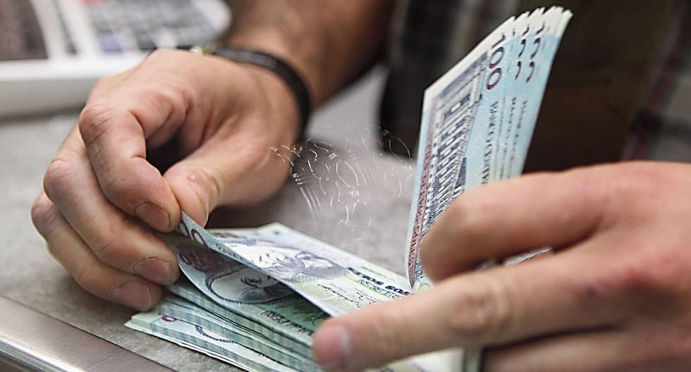 Congreso peruano presenta — Unas manos manipulan billetes de moneda peruana, ilustrando el debate sobre el retiro de fondos de las AFP y el acceso a pensiones mínimas. Foto de: Gestión
