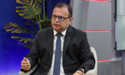 incendios forestales — Un hombre con gafas y traje oscuro habla en un estudio de televisión con una planta decorativa al fondo. Foto de: Exitosa Noticias