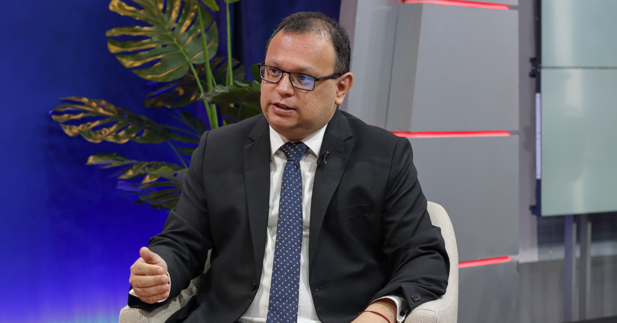 incendios forestales — Un hombre con gafas y traje oscuro habla en un estudio de televisión con una planta decorativa al fondo. Foto de: Exitosa Noticias