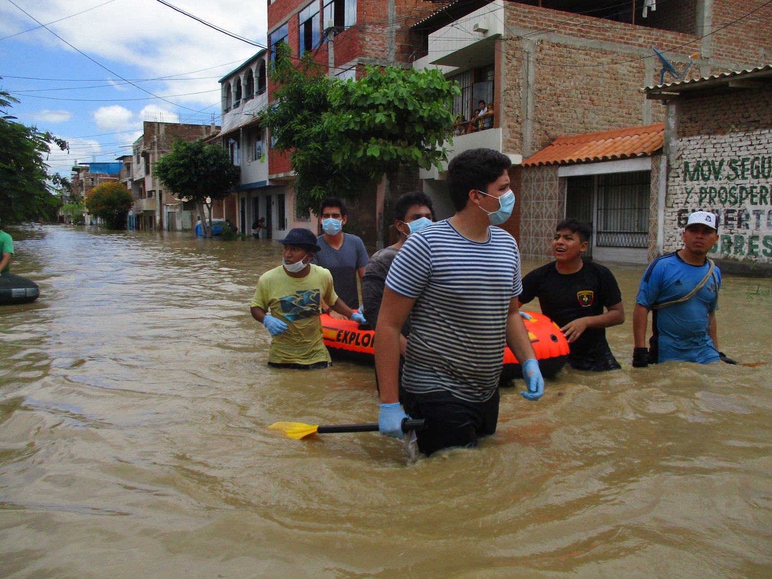 Vecinos y rescatistas atraviesan inundaciones en una zona urbana, evidenciando la falta de sistemas de alerta temprana ante los efectos de El Niño. Foto de: ANIN